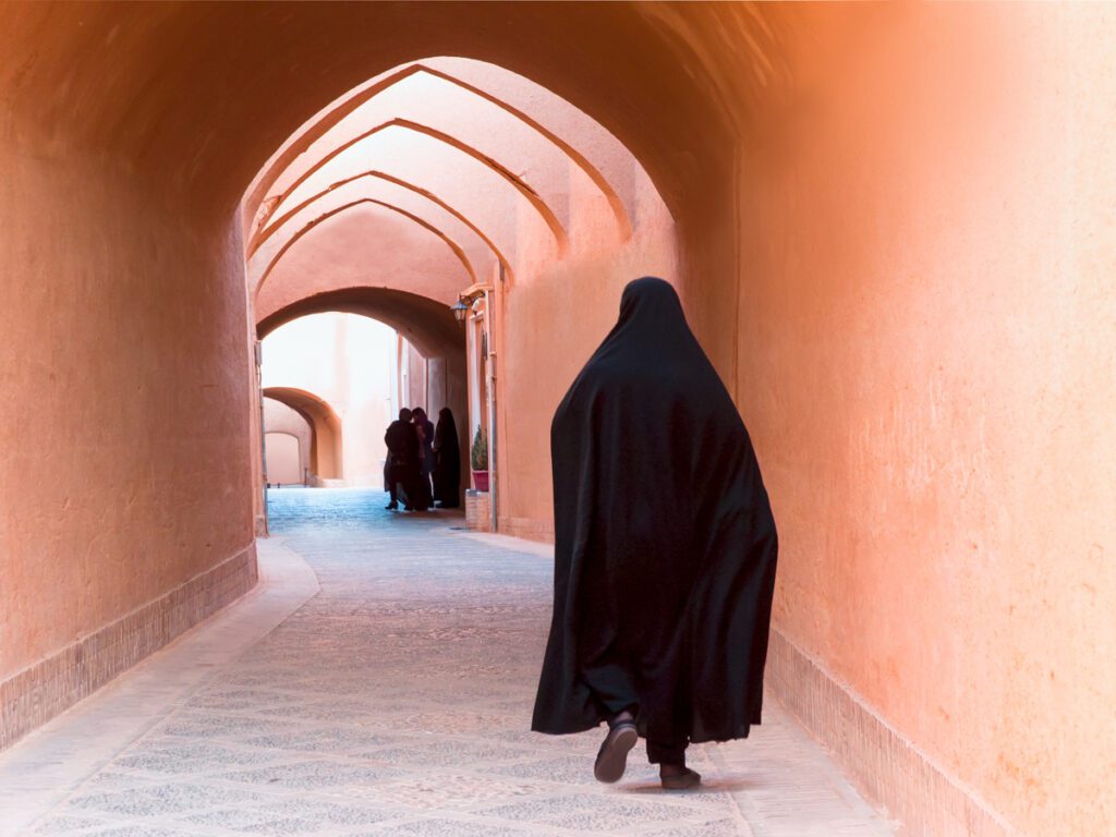 Muslimsk kvinna går i en gränd