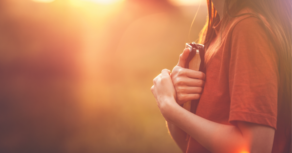 En kvinna håller om en Bibel.